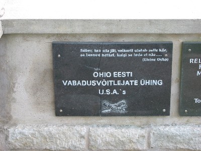 A plaque, perhaps damaged by vandals, on the Vaivara Cemetery Memorial Wall.<br> Hooligans have already desecrated this local and international community effort, and considering the care with which the wall was built, the chances are that the crack in the plaque was not weather related. This particular one marked the contribution of the Ohio Estonian Freedom Fighters Association to the construction of the memorial. Toronto's Elviine Osko, now<br> deceased, contributed the epitaph, remembering a fallen friend and his continued presence.<br> Photo: Peeter Bush - pics/2005/10946_3.jpg