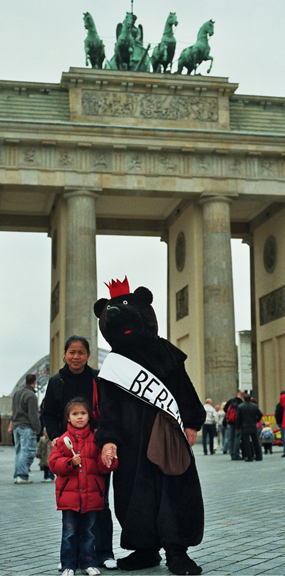 Juubeldajad Brandenburgi väravate ees Saksamaa taasühinemispäeval. On nad turistid või uusimmigrandid, ammused "wessi"-d (lääne-sakslased) või elavad nüüd endiste "ossi"-de (ida-sakslaste) piirkonnas? Kuigi on olnud oma jagu kriitikat ühinemisjärgse arengukava õnnestumise suhtes, kallistas Berliini karu tol päeval kõiki võrdväärselt, mõningaid isegi sülle haarates. Teistpool väravaid oli esinemislava ja karusellid, õllelauad ja vorstiputkad piki Tiergarteni parki läbivat Straße des 17. Juni’t. - pics/2005/11335_1.jpg