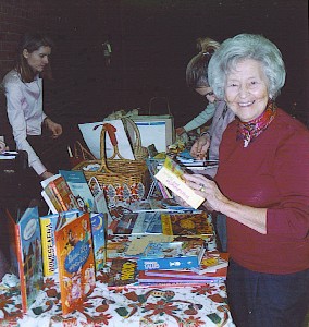 Lasteaia raamatukogu abiline Aino Toiger jõulupeo müügilaual lasteraamatutega tutvumas. Foto: M. Mölder - pics/2006/12514_1.jpg